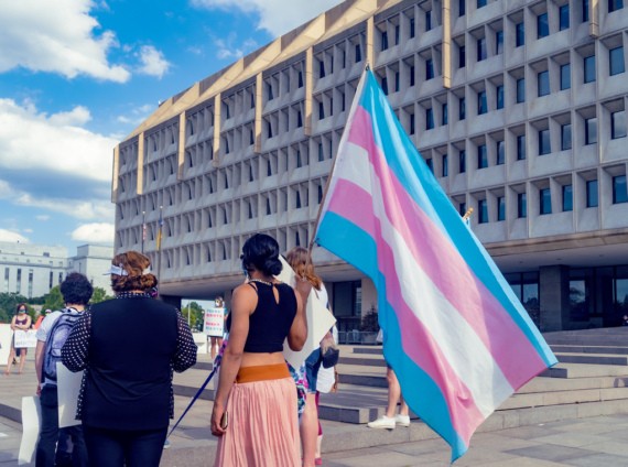 A person holds a trans flag