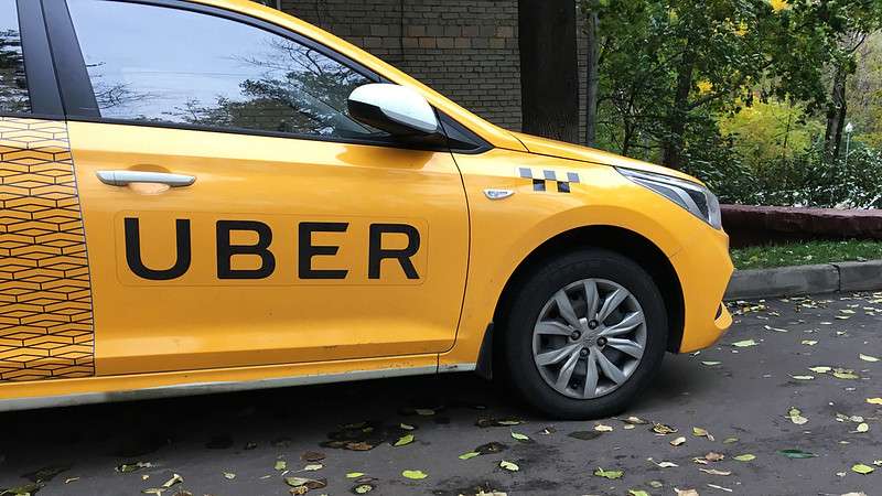 A yellow taxi with 'Uber' written on the side
