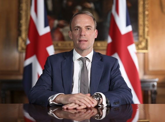 Dominic Raab sits in front of two union flags