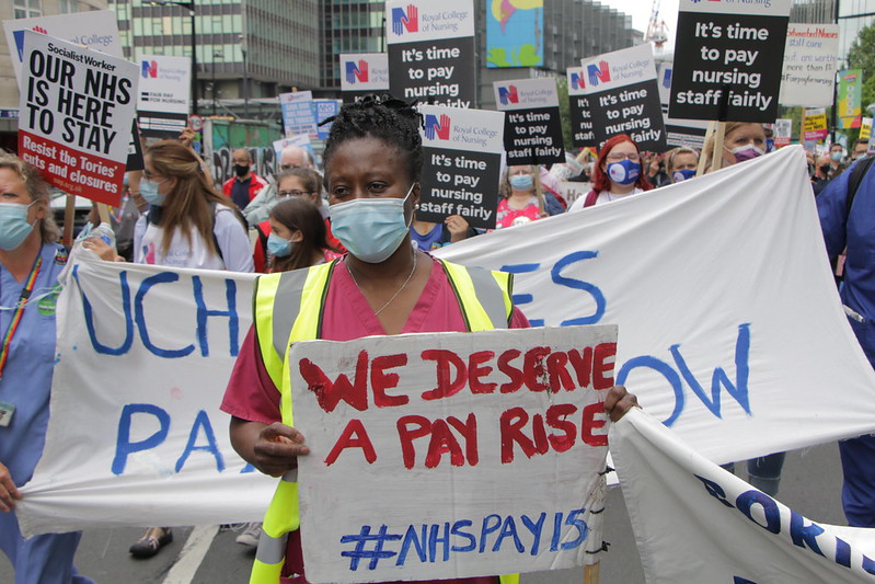 A nurse holds a placard reading "We Deserve A Pay Rise" at a RCN march