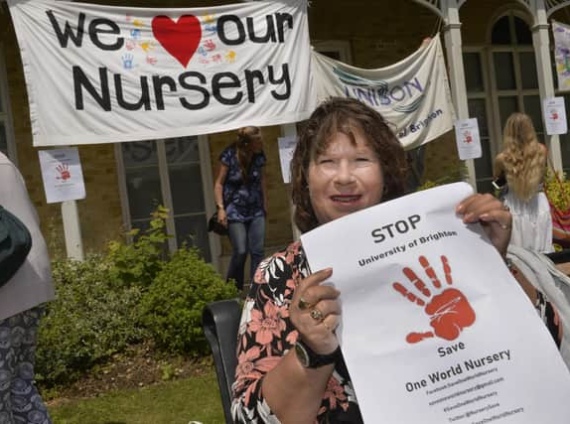 A woman holds a poster in support of the UoB One World nursery at a rally to save it