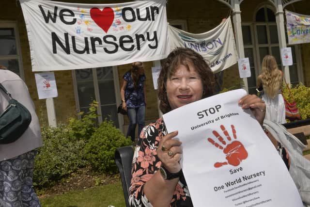 A woman holds a poster in support of the UoB One World nursery at a rally to save it