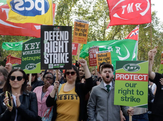 People hold placards saying "Defend the right to strike" at a TUC rally