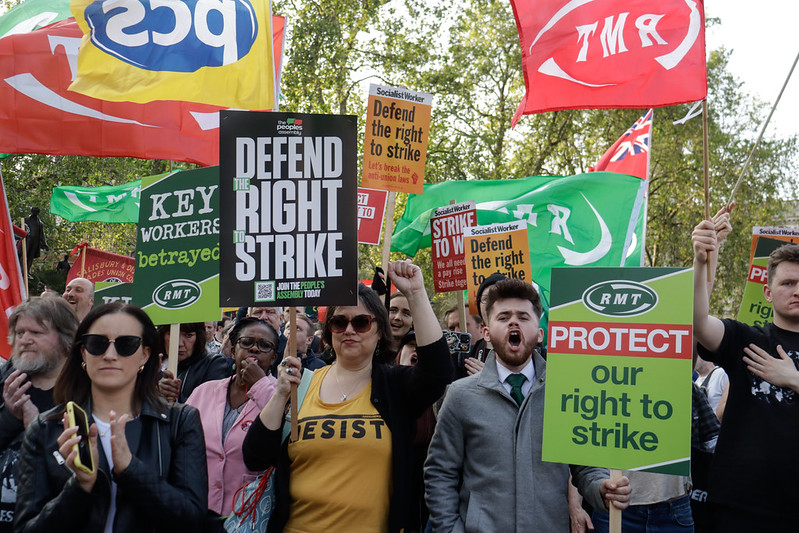 People hold placards saying "Defend the right to strike" at a TUC rally