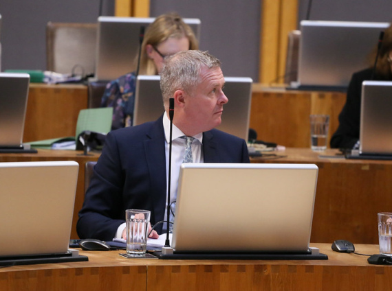 Jeremy Miles looks over his shoulder during a session in the Senedd