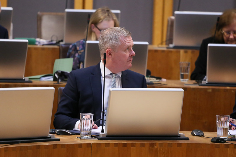 Jeremy Miles looks over his shoulder during a session in the Senedd